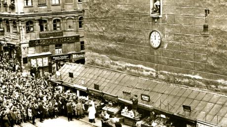Turamicheletag 1930: Die "sieben Lädla" am Fuß des Perlachturms bieten ein üppiges Warenangebot auf ausgeklappten Theken. 	