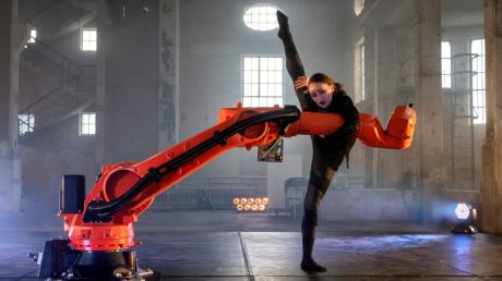 Eine Balletttänzerin des Staatstheaters Augsburg tanzt in "Kinesphere" ein Duett mit einem Roboterarm.