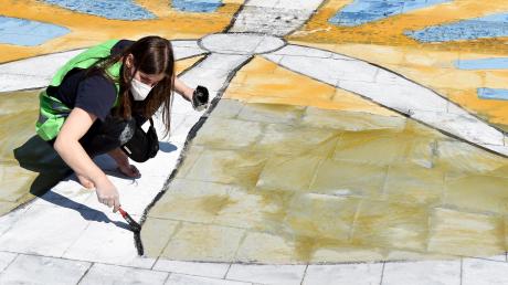 Kreativer Protest: Eine Aktivistin von Fridays For Future malt in Essen ein Windrad, während die Hauptversammlung von RWE stattfindet.  	
