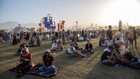 Festivalbesucher sitzen auf dem Gelände des Coachella-Festivals 2022.