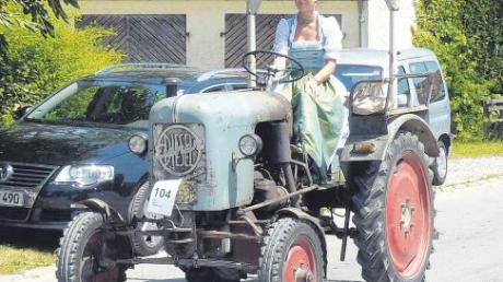 Fesche Frau auf altem Traktor. 