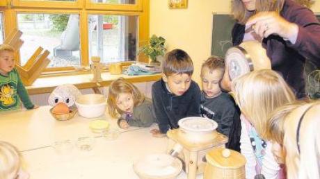 Petra Neuerburg erklärte Paula Print und den Kindern des Kauferinger Kindergartens Paul und Paulinchen wie aus Körnern Mehl gemahlen wird. 