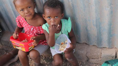 Diese süßen Kinder freuen sich über ihr Mittagessen.