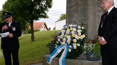 Soldaten- und Reservistenvereinsvorsitzender Hermann Wurm (links) sowie Schirmherr und Bürgermeister Leonhard Wörl legen zum Gedenken einen Kranz am Eglinger Kriegerdenkmal nieder. 