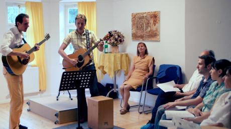 Martin Schlögl (links) und Wieland Götze spielten beim Friedensfest von Helene Walterskirchen (im gelben Kleid) weltbekannte Friedenslieder.  
