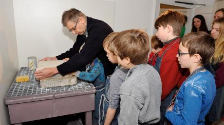 Ferienprogramm im Herkomer Museum: Andreas Pfies zeigt den Kindern wie man mit Lithosteinen druckt. Die alten Zeichnungen werden mit Aluminiumpuder weggeschliffen. 