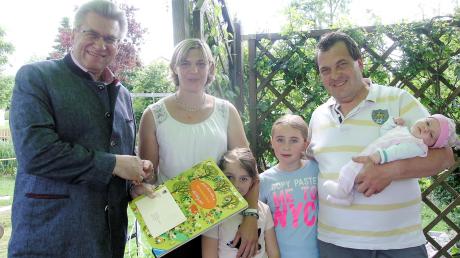 Hurlachs Bürgermeister Wilhelm Böhm überreichte an Sabrina und Martin Gerum eine Karte und ein Wimmelbuch für die kleine Marie. Mit dabei sind auch die Töchter Katharina und Juliane.