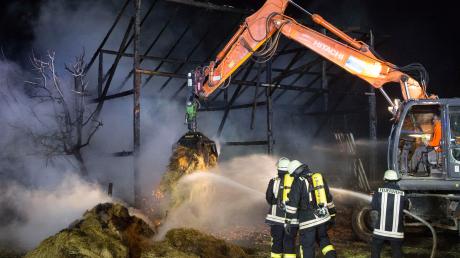 Einsatz bei Reichling: Feuerwehrleute löschten das in der völlig ausgebrannten Scheune gelagerte Stroh ab. 	