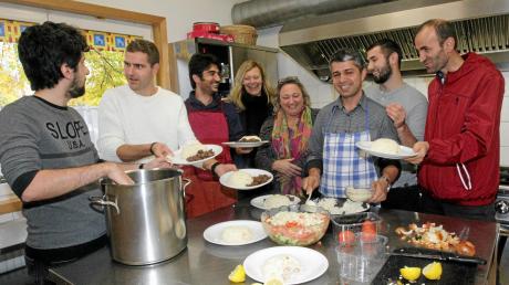 Flüchtlinge, Ehrenamtliche und Ehrenamtskoordinatorin kochen gemeinsam in der Freien Evangelischen Gemeinde in Kriegshaber. 