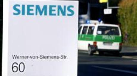 Ein Polizeiauto steht am Mittwoch (15.11.2006) in Erlangen (Mittelfranken) vor einem Bürohaus der Siemens AG. In einer groß angelegten Razzia haben rund 200 Polizisten, Staatsanwälte und Steuerfahnder am Mittwoch den Siemens-Konzern durchsucht. Laut Oberstaatsanwalt Winkler bestehe der Verdacht, dass einzelne Angestellte des Konzerns Gelder veruntreut haben. Die Ermittler nahmen rund 30 Büros und Privatwohnungen von Siemens-Mitarbeitern in München, Erlangen und anderen Orten unter die Lupe. Foto: Daniel Karmann dpa/lby +++(c) dpa - Bildfunk+++