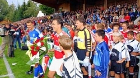 In der ersten DFB-Pokal-Hauptrunde trafen die Mannschaften des TSV Aindling und des FC Schalke 04 am Samstag (30.08.2003) im bayerischen Aindling aufeinander. Bayernligist Aindling unterlag gegen den Bundesligisten Schalke 04 mit 0:3 Toren. Eskortiert von Aindlinger Jugend betreten die Mannschaften das Spielfeld.