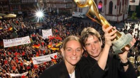 Nia Künzer (l) und Bettina Wiegmann jubeln in Frankfurt/Main mit dem WM-Pokal.