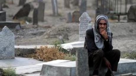 Trauer in Kabul: Ein Mann sitzt einsam auf dem Friedhof für Märtyrer des Krieges gegen sowjetische Besatzer (Archivbild). Nun wurde ein weiteres Massengrab aus der Besatzungszeit entdeckt.