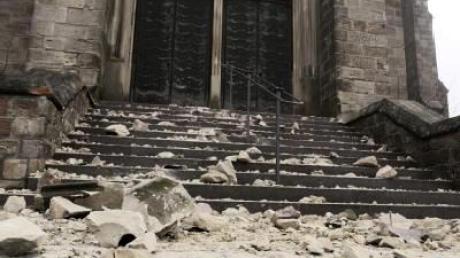 Auf der Treppe der St. Blasiuskirche in Saarwellingen liegen Steine, die sich nach dem Beben vom Kirchturm gelöst hatten.