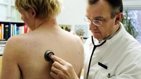 Ein praktischer Arzt untersucht in seiner Praxis einen Patienten (Archivfoto vom 2.1.2004).