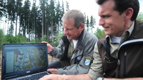 Forstingenieur Gerhard Wilhelm, rechts und Peter Birkholz vom Forstamt Krumbach mit Laptop vor einem Fichtenwald bei Krumbach