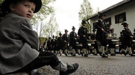 Ein in bayerische Tracht gekleideter Junge schaut am Sonntag (02.05.10) in Benediktbeuern (Bayern) einer Gebirgsschuetzenkompanie zu, die nach dem Gottesdienst in einem Festzug durch den Ort marschiert. Der Patronatstag ist das Hauptfest des "Bundes der Bayerischen Gebirgsschuetzen-Kompanien".