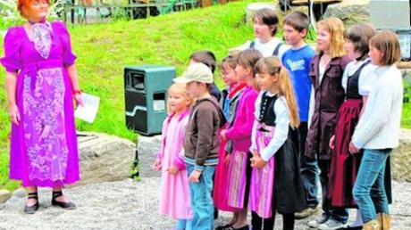 Monika Friesl-Junker (links) hatte mit den Kindern ein Singspiel einstudiert.Zahlreiche Gäste hatten sich zur Einweihung des Spielplatzes eingefunden, die musikalisch umrahmt wurde. Fotos: Wolfgang Adolf