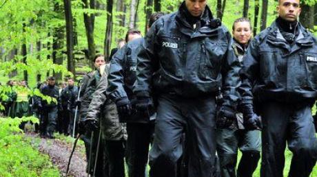 Polizisten suchen am Freitag in einem Wald bei Heidenheim-Schnaitheim Spuren. Hier scheiterte nach Polizeiangaben eine Lösegeldübergabe.