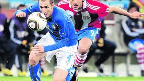 Lieferten sich in der Montagabend-Partie einen packenden Kampf: Italiens Giorgio Chiellini (links) und Paraguays Roque Santa Cruz (rechts), einst beim FC Bayern München unter Vertrag. Foto: dpa