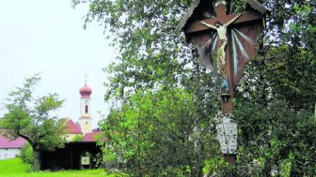 Verträumte Winkel in Hohenzell mit der Pfarrkirche St. Stephanus im Hintergrund und einem Hofkreuz. Foto: Karl Stöckner