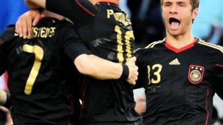 Bastian Schweinsteiger und Lukas Podolski in Vorfreude auf den Torschützen zum 1:0 gegen Argentinien: Thomas Müller (v.l.)