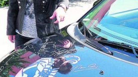 Unterschriften zieren den Tank ihres Motorrads und die Motorhaube ihres Autos.
