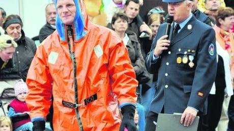 Helmut Bößhenz schlüpfte für die Modenschau in einen wasserdichten Kälteschutzanzug, Stadtbrandmeister Markus Rieß erklärte die Sonderbekleidung.