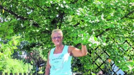Noch kann Dagmar Winzer den Anblick ihres Ginkgo-Baumes im Garten genießen. Wegen eines Nachbarschaftsstreites droht dem sogenannten Lebensbaum aber die Fällung. Foto: Christian Mühlhause