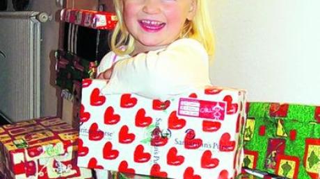 Viele Päckchen gingen für die Aktion "Weihnachten im Schuhkarton" ein. Im Bild Amelie Uhl zwischen ein paar der bunten Päckchen. Foto: Uhl