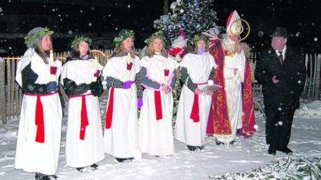 Die hl. Lucia und ihre Gefährtinnen brachten dem Nikolaus die vier Kerzen des Adventskranzes. Bischof Nikolaus (Bürgermeister Roland Dietz) und Pfarrer Paul Großmann (rechts) nahmen sie mit auf den Weg nach Weihnachten. Foto: Pfaffendorf