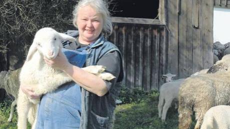 Ein einfaches Leben: Die Schäferin von Haselbach, Verena Pröbstl, mit einem Schaf im Arm und einer Schafherde im Hintergrund. Die 54-Jährige hat 22 Mutterschafe und 22 Lämmer unter ihren Fittichen. 