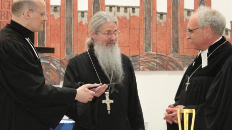 Pfarrer Claus Förster (links) und Dekan Kurt Kräß (rechts) übergeben den Schlüssel an Erzpriester Nikolai Artemoff.
