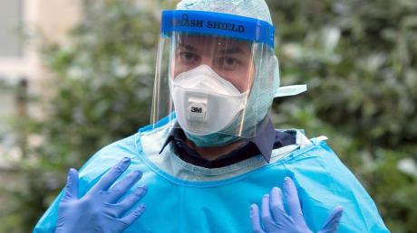 Ein Arzt präsentiert auf einer Ebola-Informationsveranstaltung in Köln einen partikeldichten Schutzanzug.