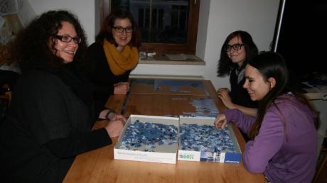 Anja Heckel und Saskia Kastello (von links) vom Dominikus-Ringeisen-Werk puzzeln mit Christina und Jessica Knoblich.  
