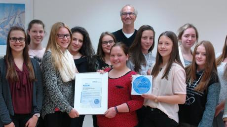 Stolz präsentieren die Schülerinnen und Lehrer Dieter Hofmann ihre Auszeichnung: Die Mindelheimer Maria-Ward-Realschule wurde wegen des Engagements in Sachen Schülerfirma jetzt zur „Junior-Premium-Schule“ ernannt.  	