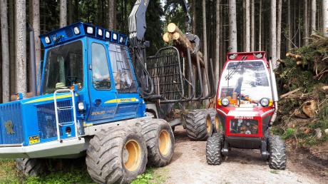 Groß trifft Klein: Links abgebildet ist ein normales Rückefahrzeug bei Waldarbeiten, rechts sieht man die Mini-Version, Urban Melders „Rückezwerg“.  	