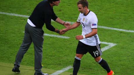 Bei der EM 2016 gibt der damalige Bundestrainer Joachim Löw (l) Mario Götze bei dessen Auswechslung die Hand.
