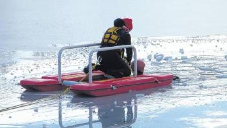 Helfer der Wasserwacht zeigen bei einer Übung, wie schwierig die Rettung eines im Eis eingebrochen Menschen ist. 