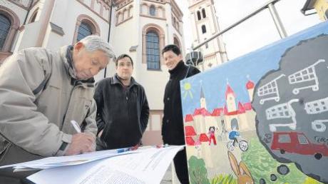 Franz-Xaver Mayershofer (links) unterschreibt für ein Bürgerbegehren gegen Märkte auf der Hasenwiese. Auf dem Kirchplatz sammeln Thomas Schwarzer und Michael Gutter (rechts) auch am Samstag wieder Autogramme.  