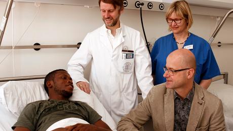 Luther Erhirhie (links) floh vor dem Terror in Nigeria nach Ulm. Im Universitätsklinikum wurde er jetzt operiert. Professor Götz Röderer, Heike Natterer und Matthias Hambücher (sitzend) kümmern sich um den Patienten. 
