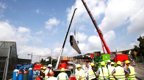 An zwei Kränen hängt ein 72 Tonnen schweres Stahlteil, das erste Stück der geplanten Kienlesbergbrücke, auf der künftig die Straßenbahn fahren soll. Bei einem Pressetermin informierten die Bauherren über den aktuellen Stand. 