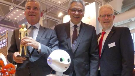 Thomas Strobl, Gunter Czisch und Karl-Heinz Raguse (von links) mit Roboter Pepper.  	