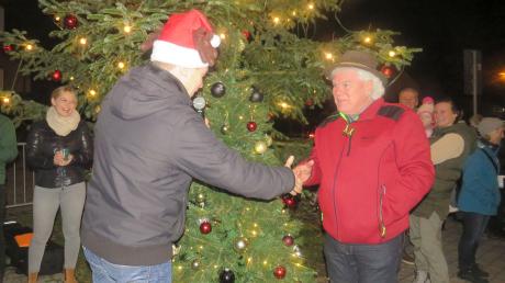 Vereinsringvorsitzender Christian Glöckler gratuliert dem Besitzer des gespendeten Fernseh-Christbaumes in Burlafingen. 