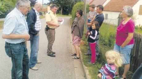 Diskussion vor Ort in der Kundinger Helenenstraße: Vertreter von Gemeinde und Polizei mit einigen Mitgliedern der Familien Hugl.  