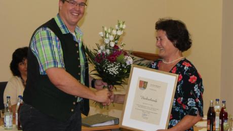 Bürgermeister Tobias Gensberger bedankte sich bei Walburga Göbel für ihren Einsatz mit einem Blumenstrauß und einer Urkunde. 
