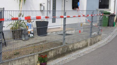 Das rot-weiße Flatterband der Polizei riegelt das Haus in Kösching ab, in dem am Freitagabend ein Doppelmord passiert ist. 	 	