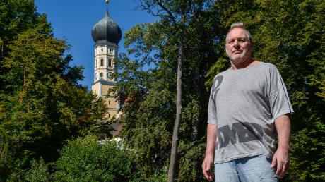 Andreas Waldegger vor der Kirche Mariä Himmelfahrt in Walleshausen. Er wohnt in der Nachbarschaft und sieht durch das Angelusgeläut um 5 Uhr morgens seine Nachtruhe gestört.