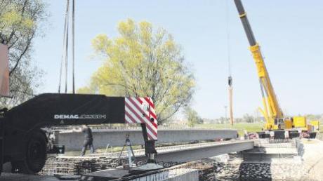 Gerade noch vor Ostern hoben zwei Autokräne vier 80-Tonnen-Betonspannträger für die neue Wörnitzbrücke bei der Wennenmühle ein. In den kommenden Wochen soll jetzt noch die anschließende Kreisstraße ausgebaut werden.  