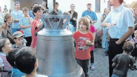 Pfarrer Müller mit Enkingern und ihrer neuen Glocke. Am kommenden Sonntag wird sie beim örtlichen Brunnenfest eingeweiht.  